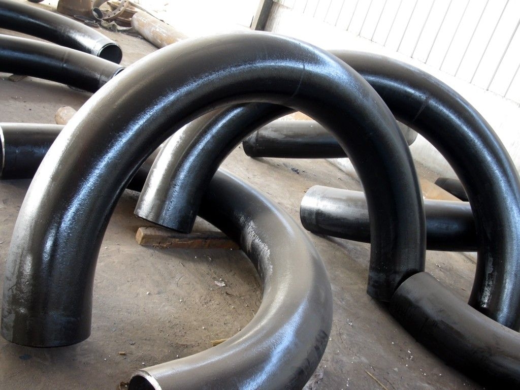 Large carbon steel pipe bends and fittings in an industrial yard